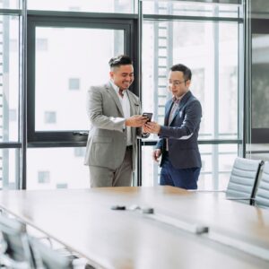two men shaking hands in a conference room