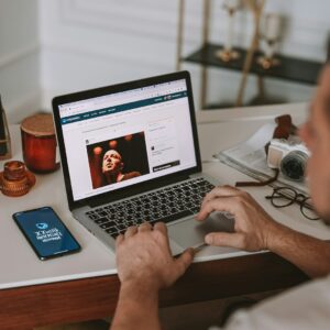 a man sitting at a desk using a laptop computer