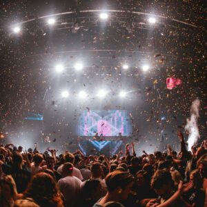 confetti falling from above at music performance with huge crowd