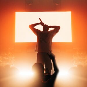 a man standing in front of a large screen