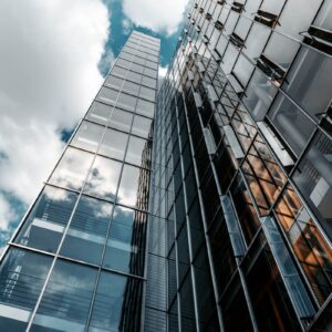 low angle photography of glass building under cloudy sky