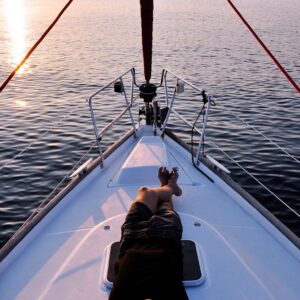 man lying on white boat