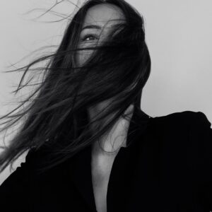grayscale photography of woman wearing long-sleeved shirt